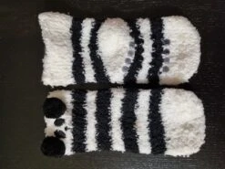 Chaussettes De Noël Pour Bébé En Noir Et Blanc Avec Un Joli Visage D'animal Emballées Dans Un Emballage Super Mignon Que Vous Pouvez Accrocher Dans Le Sapin De Noël. -Jingle Bells Boutique 1200x899 1